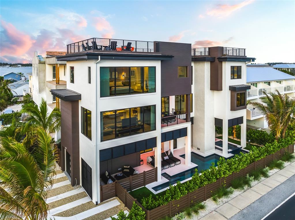 An exterior view of a modern three-story house with a rooftop deck and swimming pool — 101 7TH STREET S, BRADENTON BEACH, FL