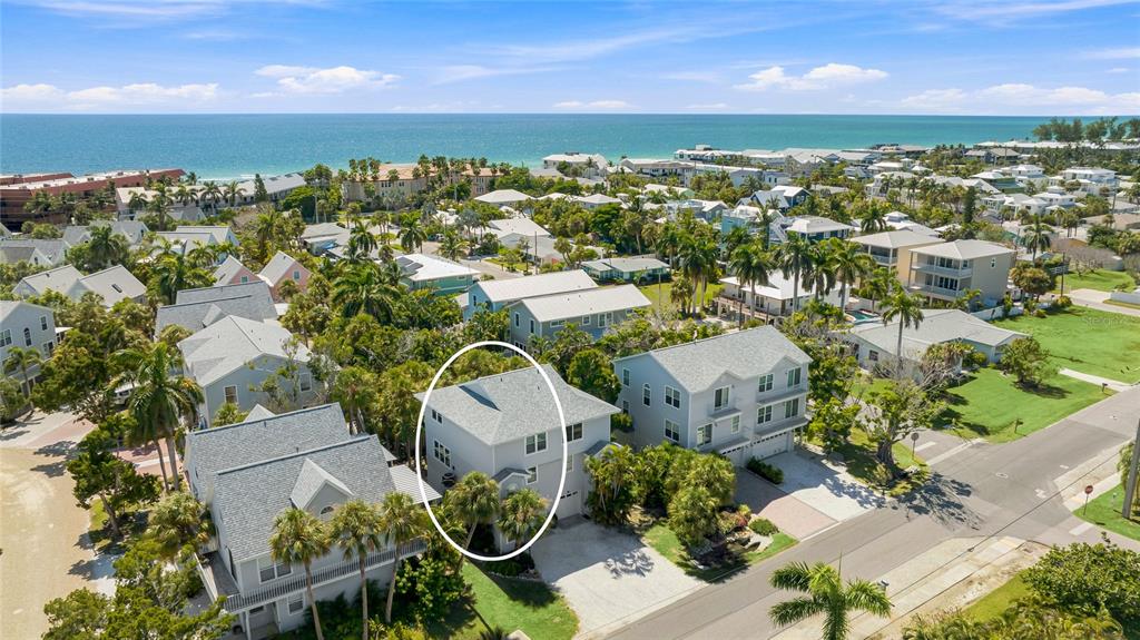 An aerial view of a two-story house surrounded by palm trees near the ocean — 6250 HOLMES BOULEVARD UNIT 24, HOLMES BEACH, FL