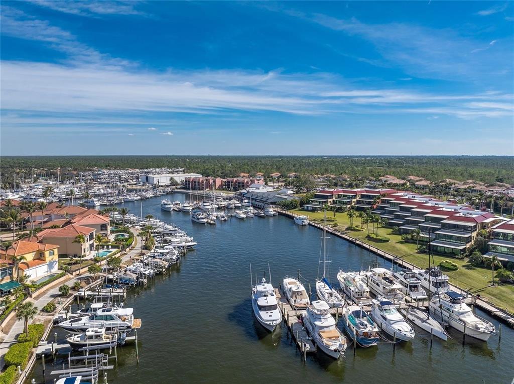 An aerial view shows a marina with numerous docked boats and surrounding residential buildings — 2064 LITTLE PINE CIRCLE, PUNTA GORDA, FL