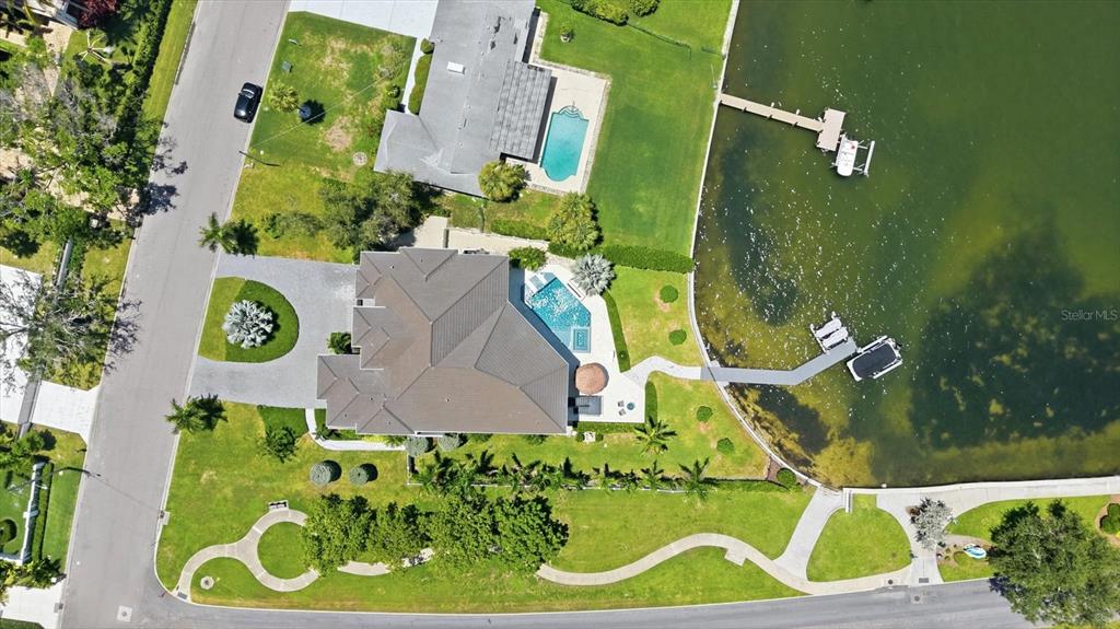 An aerial view shows two waterfront houses with swimming pools, private docks, and landscaped yards — 387 S SHORE DRIVE, SARASOTA, FL