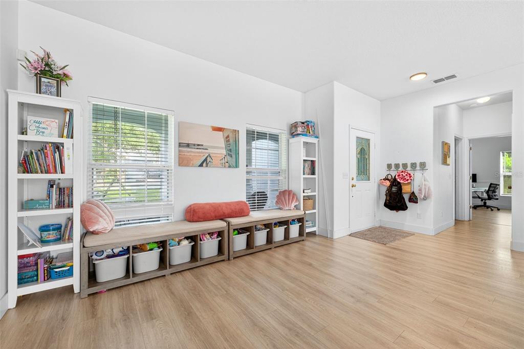 A bright room features light wood flooring, white walls, built-in storage benches, and bookshelves — 20930 SULLIVAN RANCH BOULEVARD, MOUNT DORA, FL