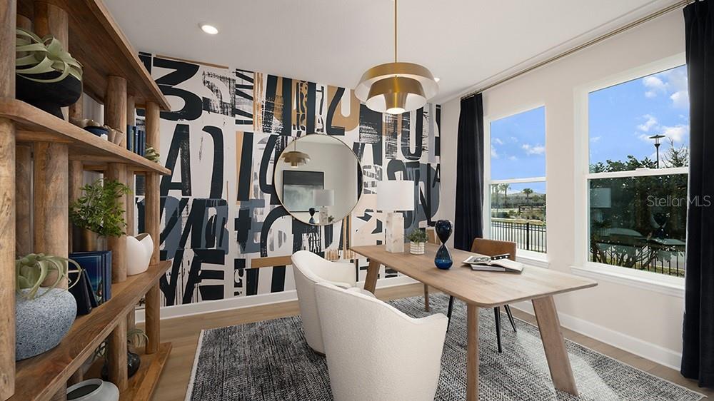 A home office features a graphic wallpaper accent wall, wooden desk, and large windows — 10851 ECLIPSE STREET, SARASOTA, FL