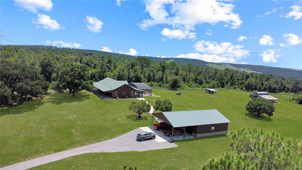 An aerial view shows a house with a pool, a carport, and a barn on land — 12150 SKYVIEW LANE UNIT 0, CLERMONT, FL