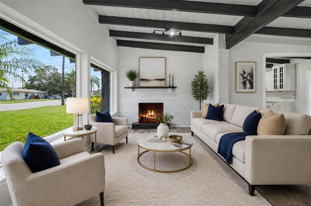 A living room features a white brick fireplace, exposed ceiling beams, and large windows — 63 PALM BOULEVARD, DUNEDIN, FL