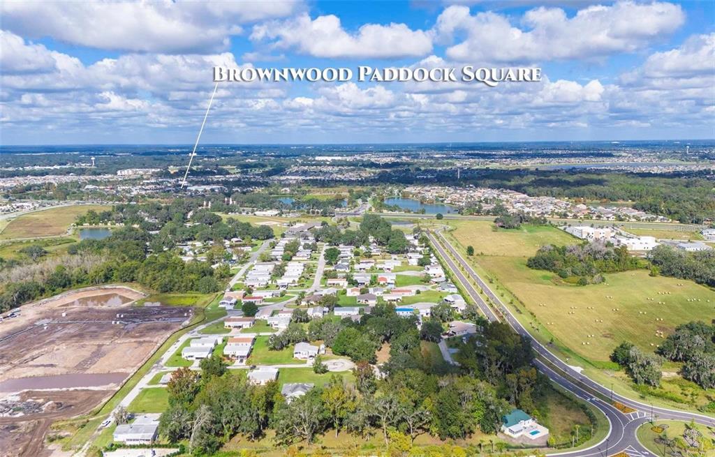 This aerial view shows a residential neighborhood with a road and a construction site nearby — LOT 22 BLK D STRATFORD COURT, WILDWOOD, FL