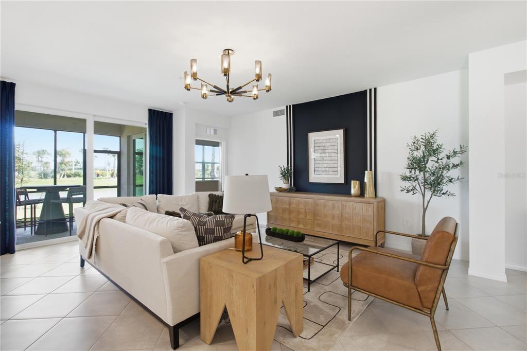 A living room features a white sofa, a leather chair, and a dark accent wall — 19235 CHERRYSTONE WAY UNIT 101, LAKEWOOD RANCH, FL