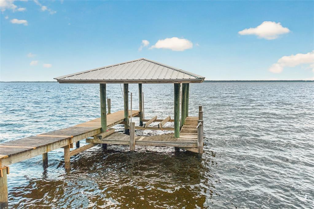 A wooden dock extends into a large lake under a blue sky with clouds — 6373 JACK WRIGHT ISLAND ROAD, ST AUGUSTINE, FL