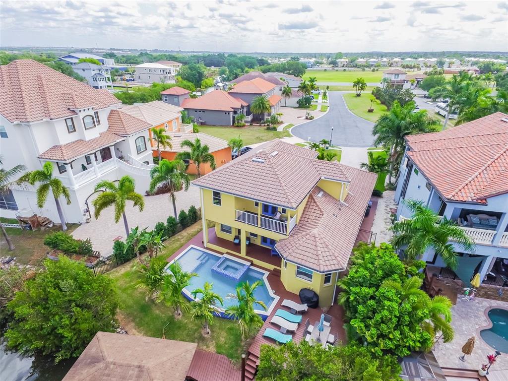 An aerial view shows a yellow two-story house with a pool and a tiled roof — 539 TREVISO DRIVE, APOLLO BEACH, FL