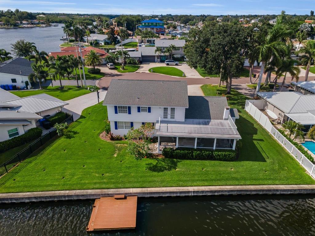 An aerial view of a two-story waterfront house with a dock and a screened porch — 1310 41ST AVENUE NE, ST PETERSBURG, FL