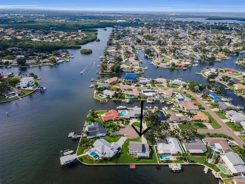 An aerial view shows a waterfront house with a pool at the end of a cul-de-sac — 1310 41ST AVENUE NE, ST PETERSBURG, FL