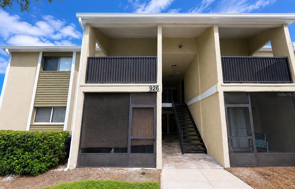 The exterior of a two-story apartment building features a screened patio and an outdoor staircase — 926 LAKE DESTINY ROAD UNIT G, ALTAMONTE SPRINGS, FL