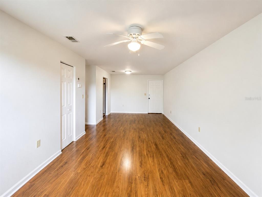 An empty room with white walls, wood-look flooring, a ceiling fan, and a white door — 926 LAKE DESTINY ROAD UNIT G, ALTAMONTE SPRINGS, FL