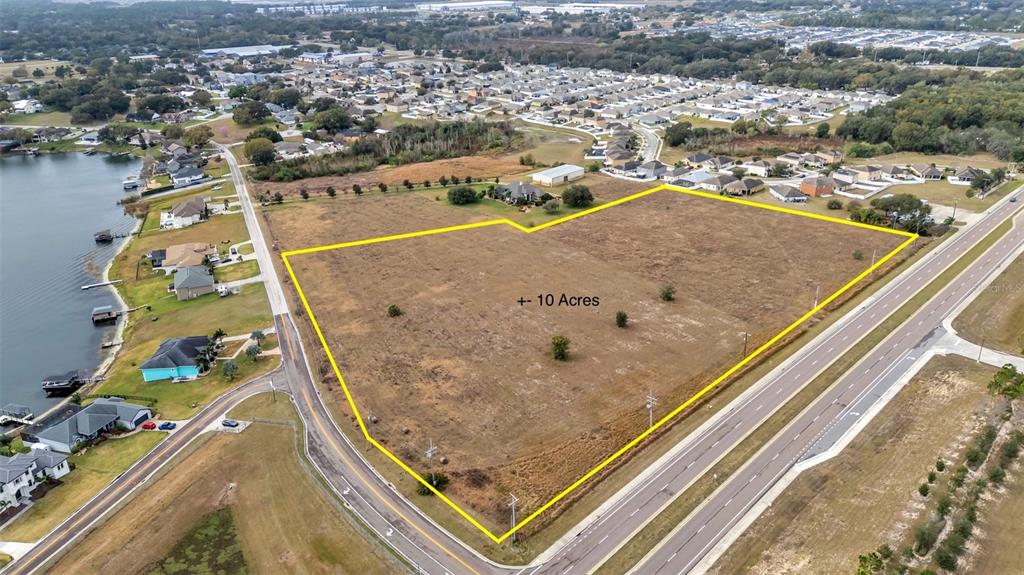 An aerial view shows a large, vacant, rectangular plot of land outlined in yellow — 0 OLD BERKLEY RD, AUBURNDALE, FL