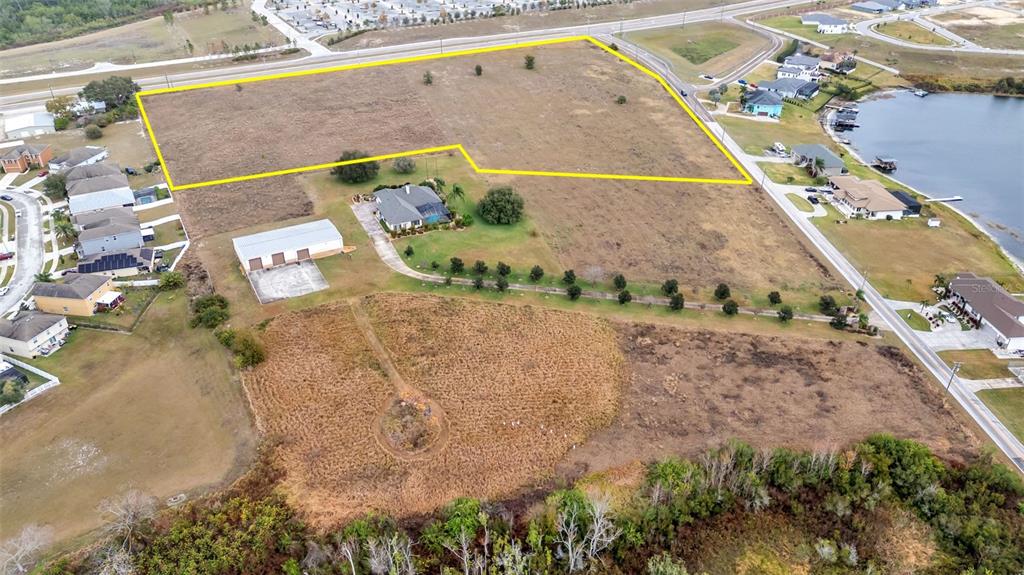 An aerial view shows a large, yellow-outlined vacant lot next to a house and lake — 0 OLD BERKLEY RD, AUBURNDALE, FL