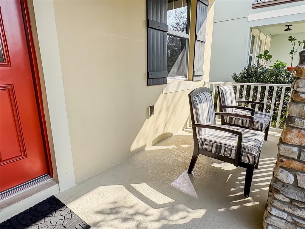 A front porch features a red door, stone columns, and a white railing — 8607 RANDAL PARK BOULEVARD, ORLANDO, FL
