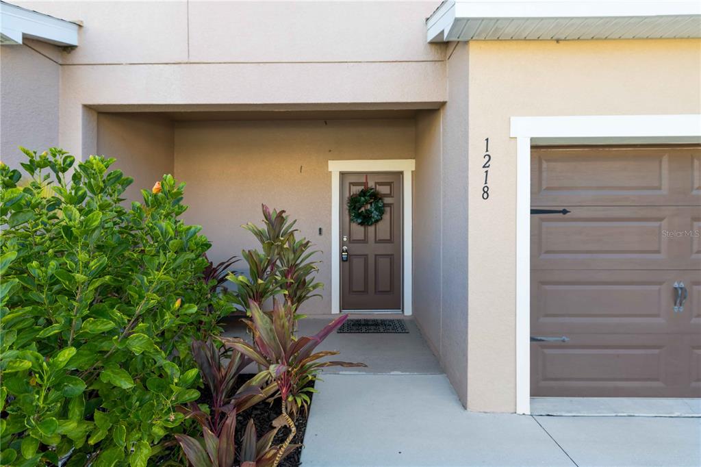 The exterior view shows a front entrance with a brown door and a garage — 1218 GRANTHAM DRIVE, SARASOTA, FL