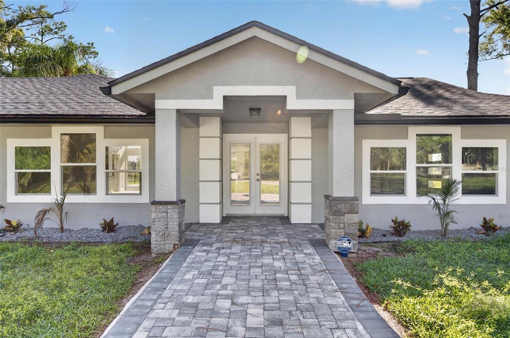 A gray house with a stone-accented entryway, a paved walkway, and white-trimmed windows — 401 N 1ST STREET, LAKE MARY, FL