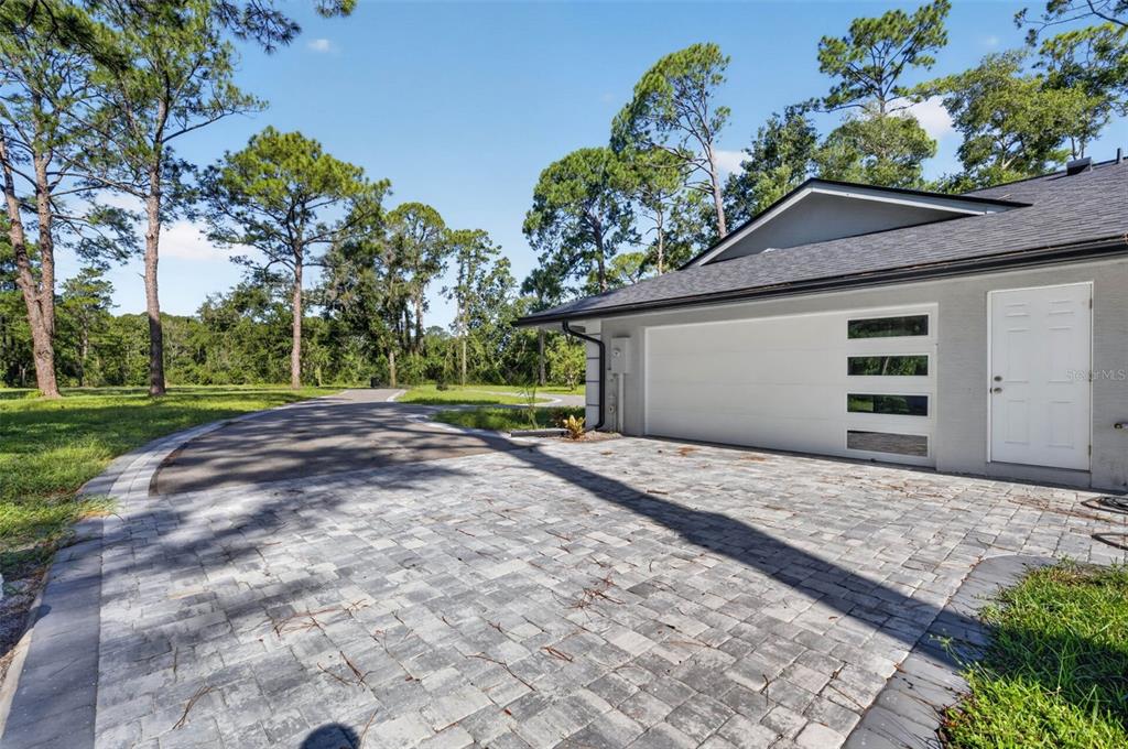 A paved driveway leads to a gray house with a white garage door and side door — 401 N 1ST STREET, LAKE MARY, FL