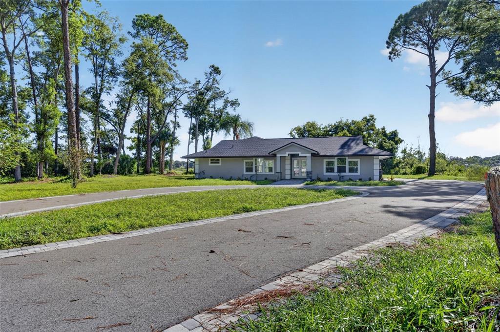 A gray single-story house with a circular driveway sits on a grassy lot with trees — 401 N 1ST STREET, LAKE MARY, FL