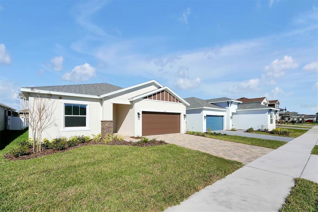 A single-story suburban house with a brown garage door and a paved driveway — 5745 WALLIS LANE, ST CLOUD, FL