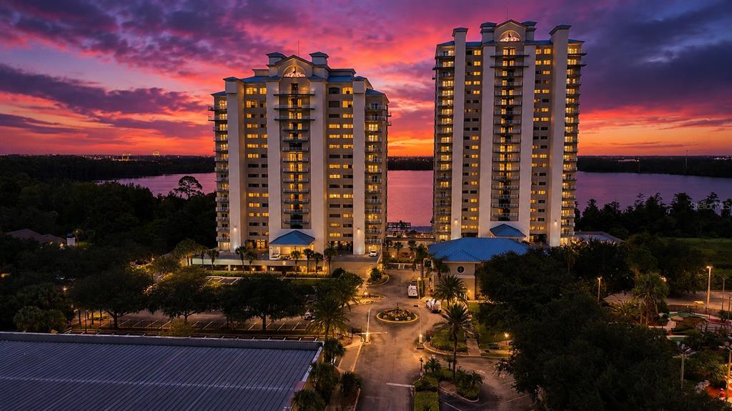 An aerial view shows a large swimming pool, two hot tubs, and surrounding apartment buildings — 13415 BLUE HERON BEACH DRIVE UNIT 407, ORLANDO, FL