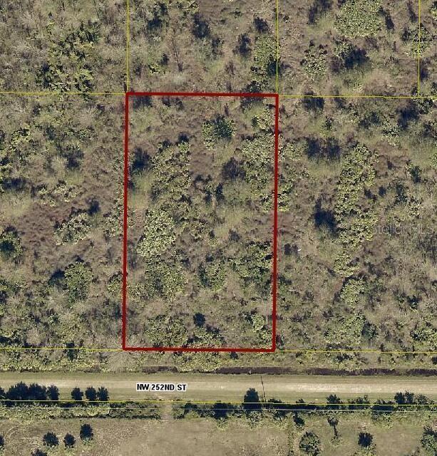 An aerial view shows a rectangular, undeveloped plot of land bordering a dirt road — 15839 NW 252ND STREET, OKEECHOBEE, FL