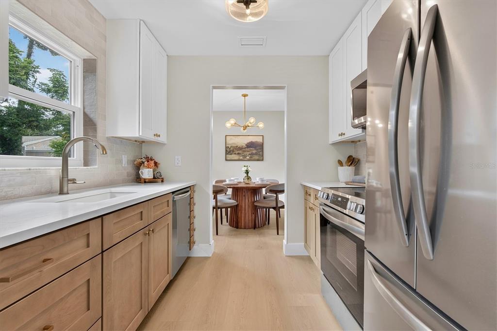 A living room features a slatted wood accent wall, two green armchairs, and a sofa — 5305 E 98TH AVENUE, TEMPLE TERRACE, FL