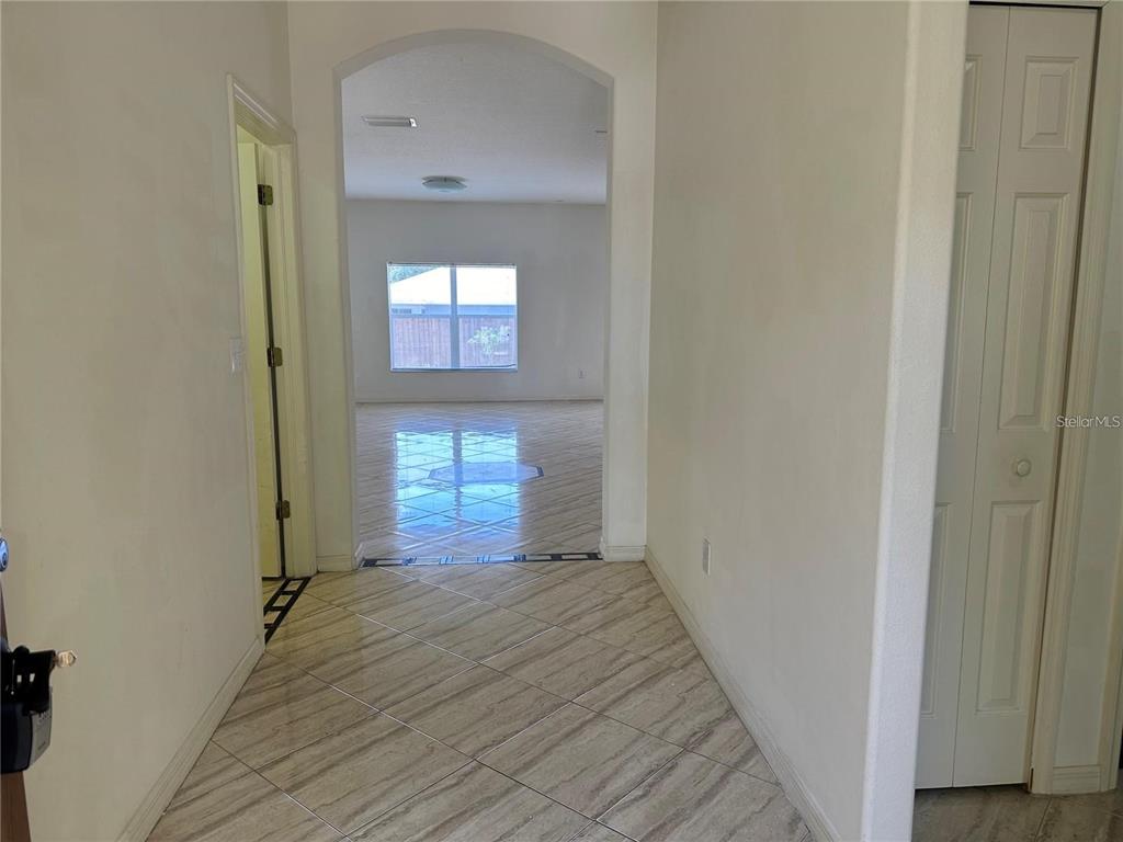 A tiled entryway leads through an arched doorway into a bright, open-concept living area — 903 COADE STONE DRIVE, SEFFNER, FL