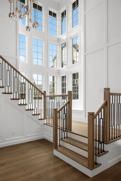 This rendering shows a grand foyer with a staircase, chandelier, and a view into a kitchen — 10300 WINTER SPARKLE CIRCLE, GOLDEN OAK, FL