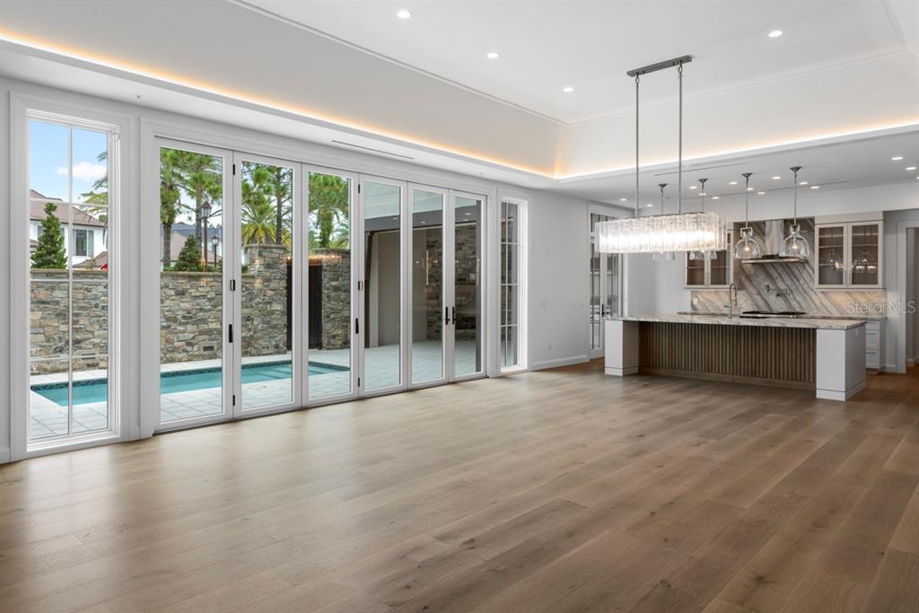This rendering shows a modern bedroom with a tray ceiling, chandelier, and a seating area — 10300 WINTER SPARKLE CIRCLE, GOLDEN OAK, FL