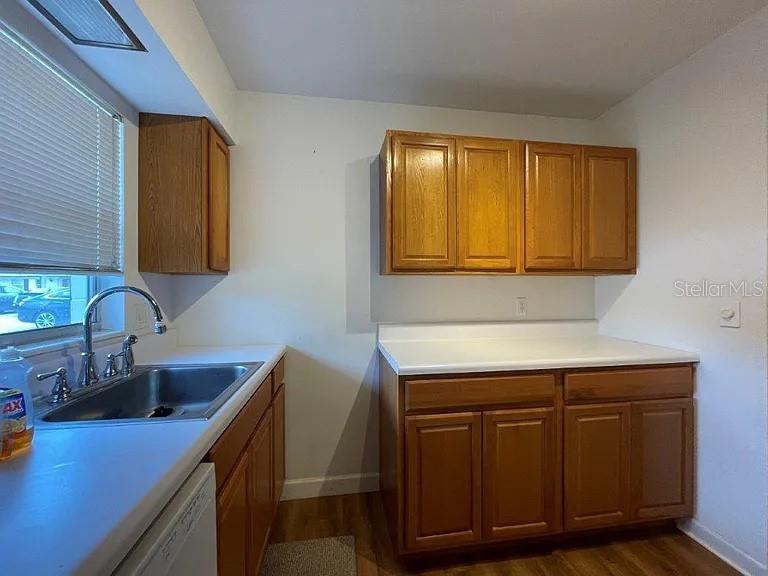 A kitchen features wood cabinets, white countertops, a stainless steel sink, and a window — 720B E MINNESOTA AVENUE UNIT B, DELAND, FL