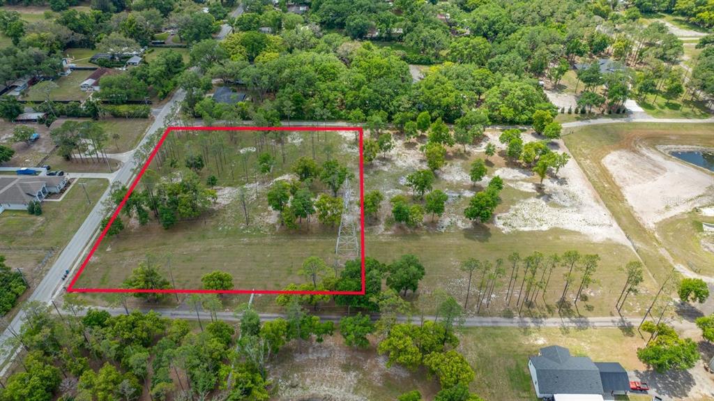 An aerial view shows a rectangular plot of land outlined in red with scattered trees — 0 HANNA ROAD, LUTZ, FL