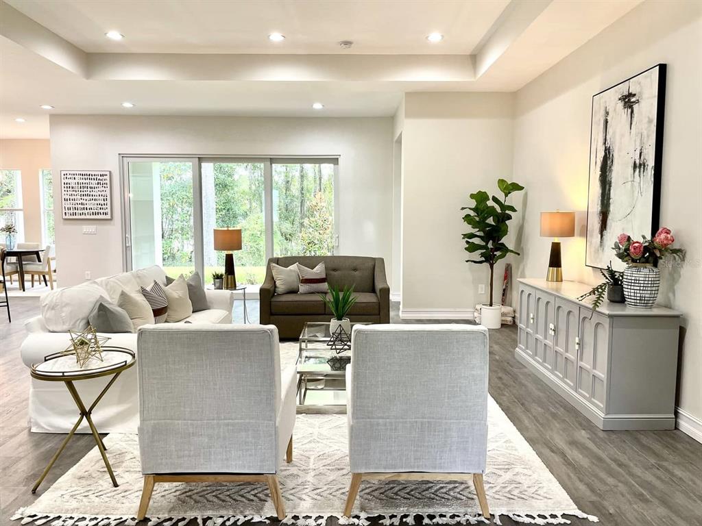 A living room features a white sofa, two armchairs, a brown loveseat, and a console table — 1973 NW 85TH LOOP, OCALA, FL
