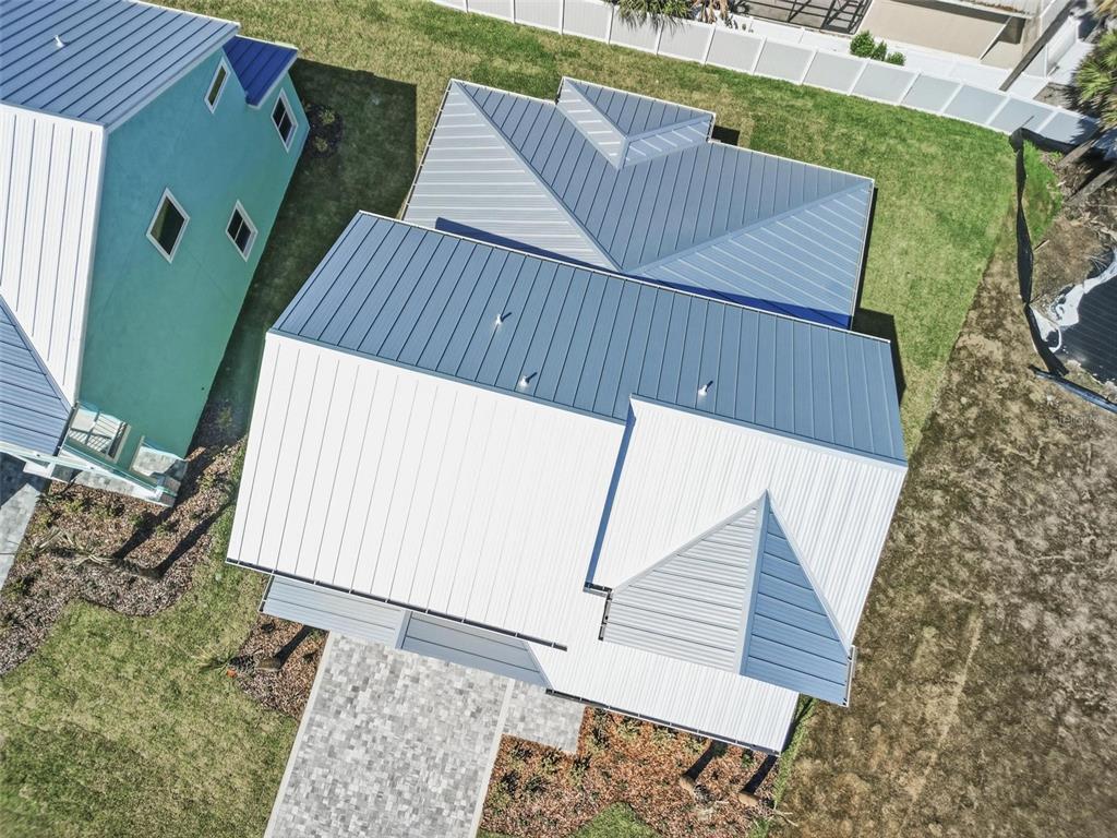 An aerial view shows the metal roofs of two adjacent houses and a paved driveway — 112 BEACHVIEW DRIVE, ORMOND BEACH, FL