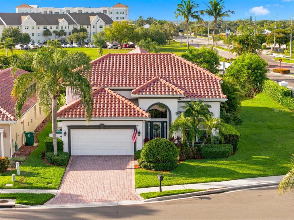An exterior view of a single-story house with a tile roof and a brick driveway — 1110 3RD STREET E, PALMETTO, FL