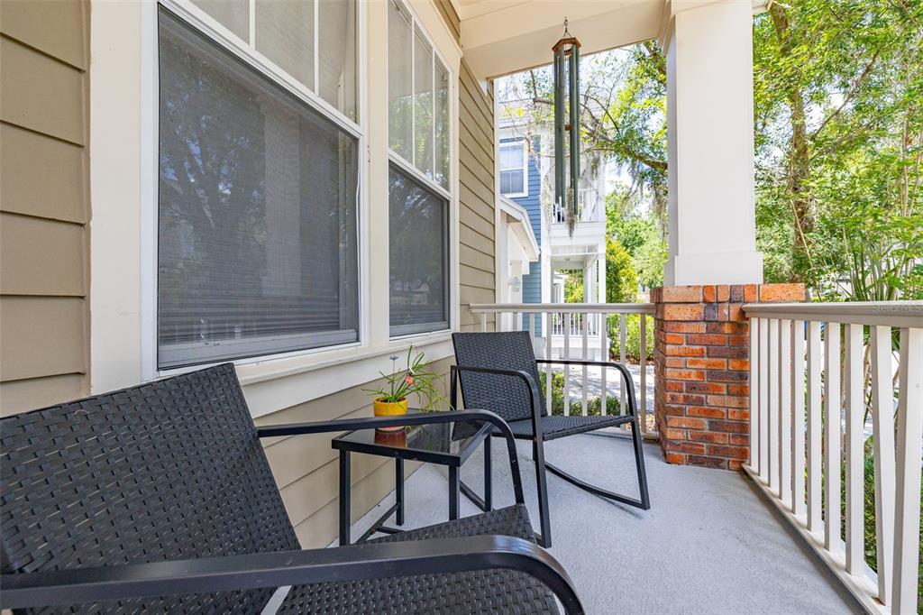 A blue front door with a hello sign sits on a porch with rocking chairs — 1024 BANKS ROSE STREET, CELEBRATION, FL