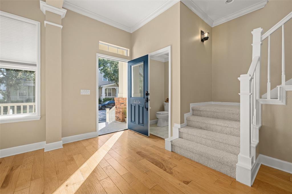 A covered porch features a brick-based column, white railing, and a view of neighborhood houses — 1024 BANKS ROSE STREET, CELEBRATION, FL