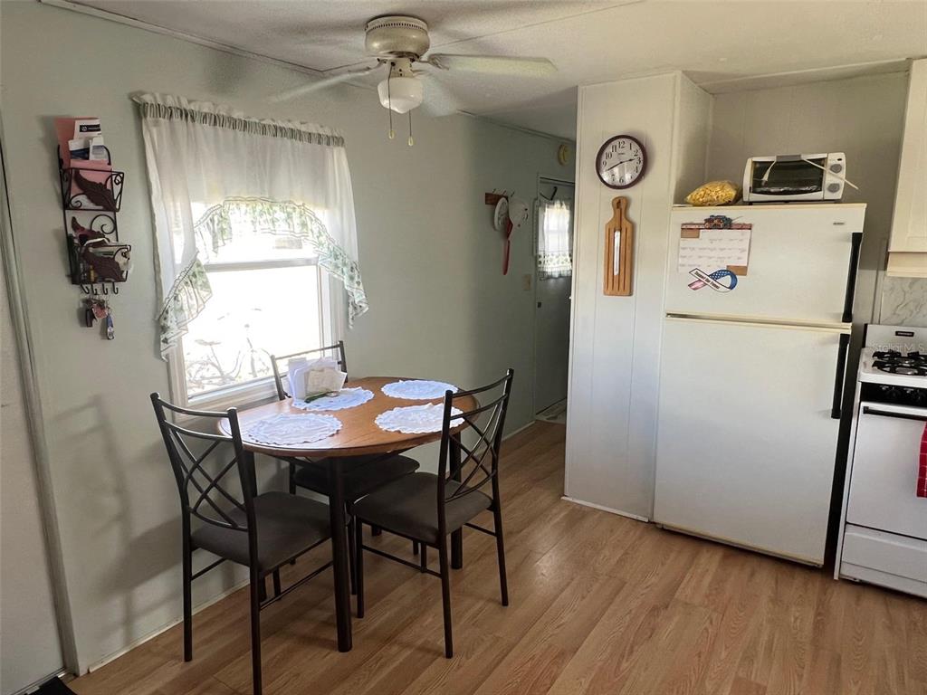 A kitchen and dining area with a round wooden table, chairs, and a white refrigerator — 12674 SEMINOLE BOULEVARD UNIT C6, LARGO, FL