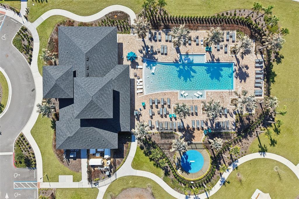 An aerial view shows a building with a dark roof next to a swimming pool — 3110 SANCTUARY DRIVE, CLERMONT, FL