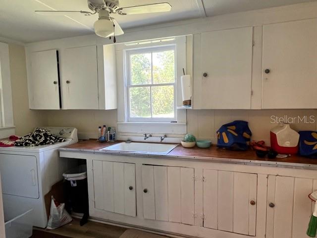 A kitchen features white cabinets, a sink, a ceiling fan, and a washing machine — 9559 SE STATE ROAD 100, STARKE, FL