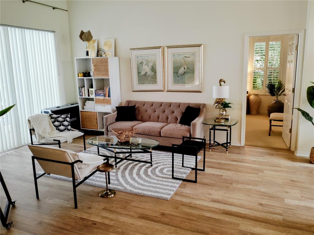 A living room features a mauve sofa, two accent chairs, and a glass coffee table — 11939 56TH STREET E, PARRISH, FL