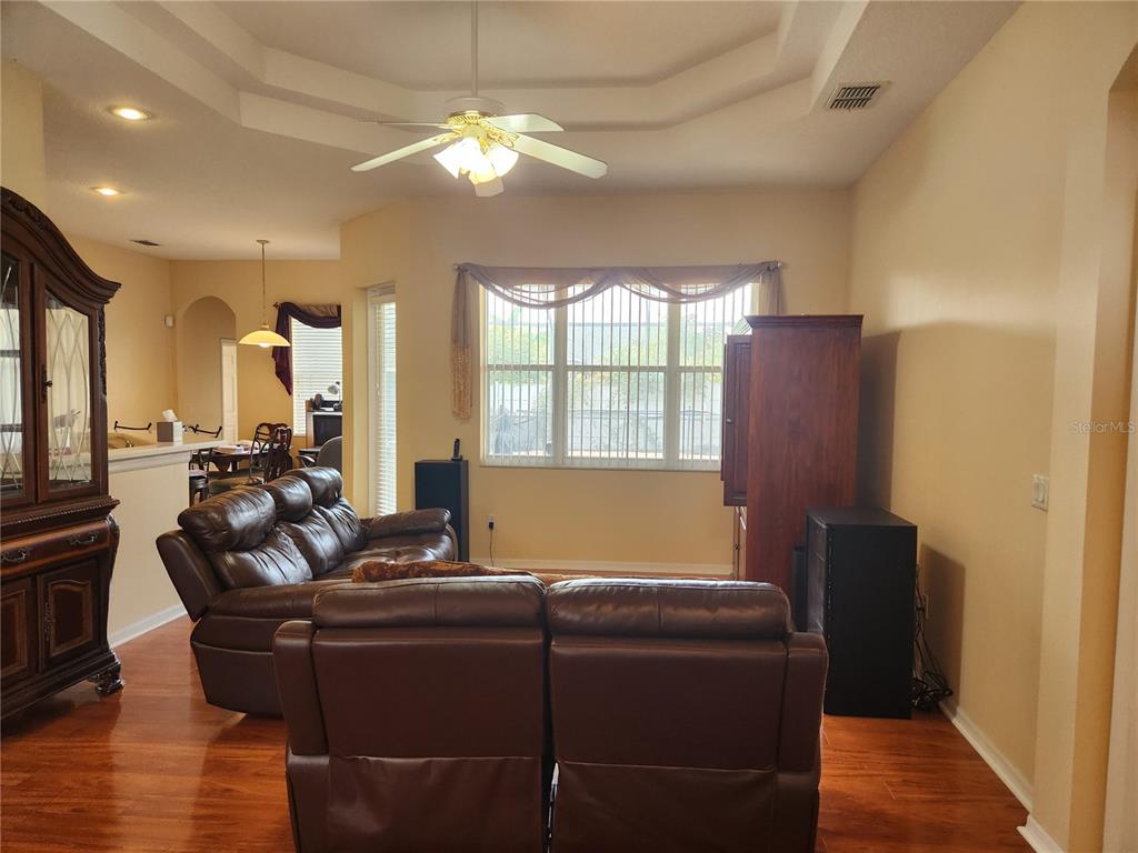 A living room with wood flooring, a leather sofa, and a ceiling fan — 1629 CANOE DRIVE, LUTZ, FL
