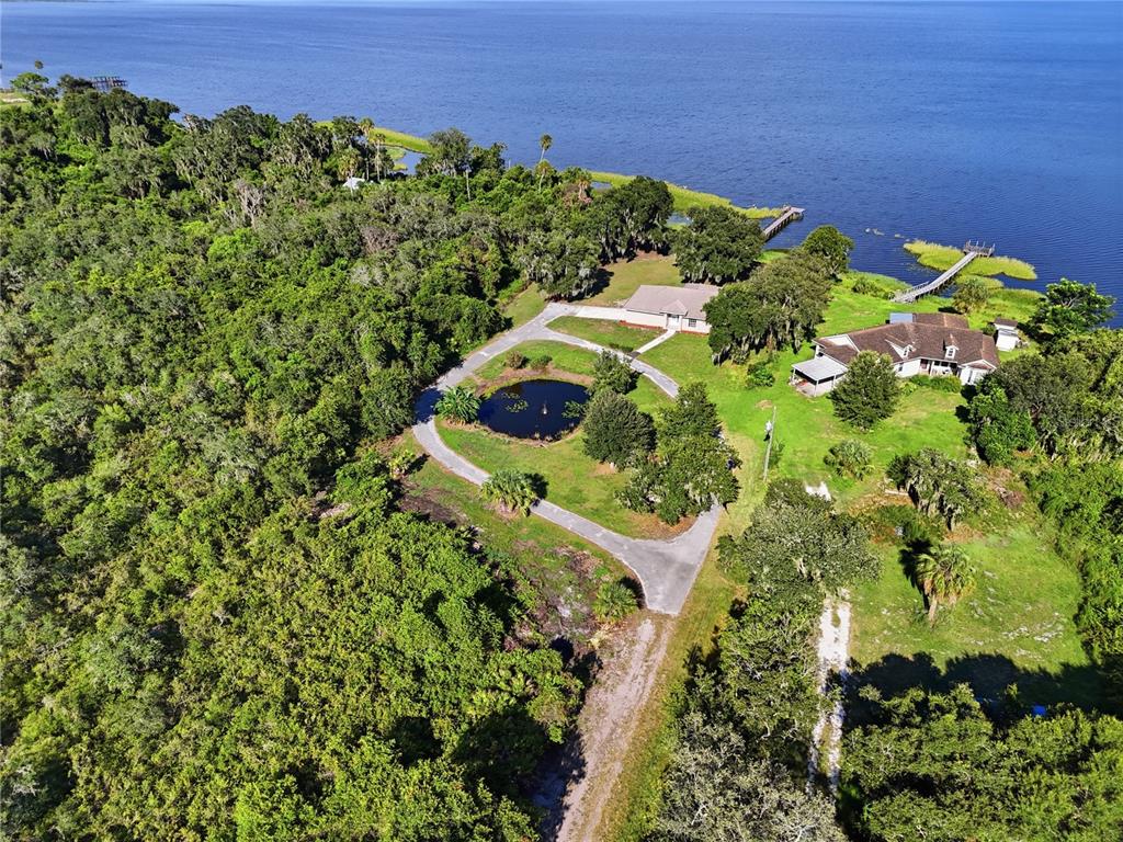 An aerial view shows two houses, a circular driveway, and a pond near a lake — 3005 SCRUB OAK LANE, LAKE WALES, FL