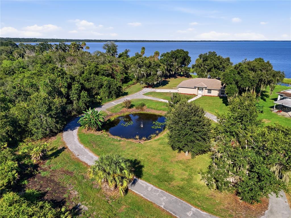 An aerial view shows a house with a circular driveway and pond near a lake — 3005 SCRUB OAK LANE, LAKE WALES, FL