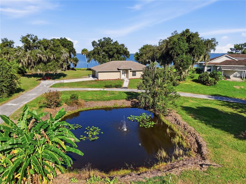An aerial view of a house with a pond, fountain, and large trees near water — 3005 SCRUB OAK LANE, LAKE WALES, FL