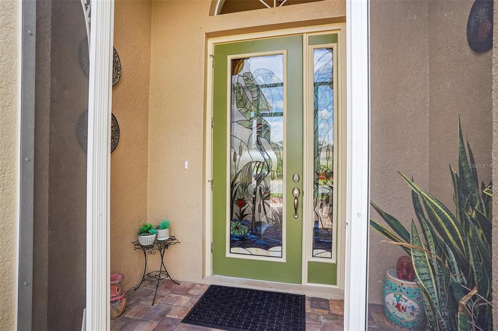 A single-story house exterior with a two-car garage, arched entryway, and landscaped front yard — 10086 KETCH KAY LANE, OXFORD, FL