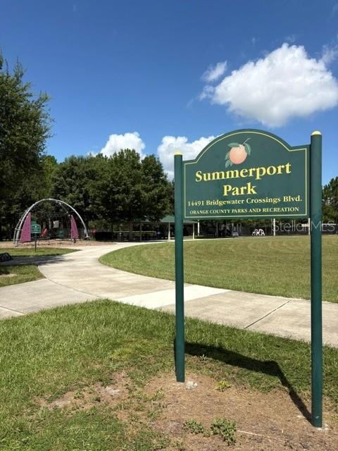 A park sign stands in front of a paved walkway and a playground structure — 14776 MAGNOLIA RIDGE LOOP, WINTER GARDEN, FL