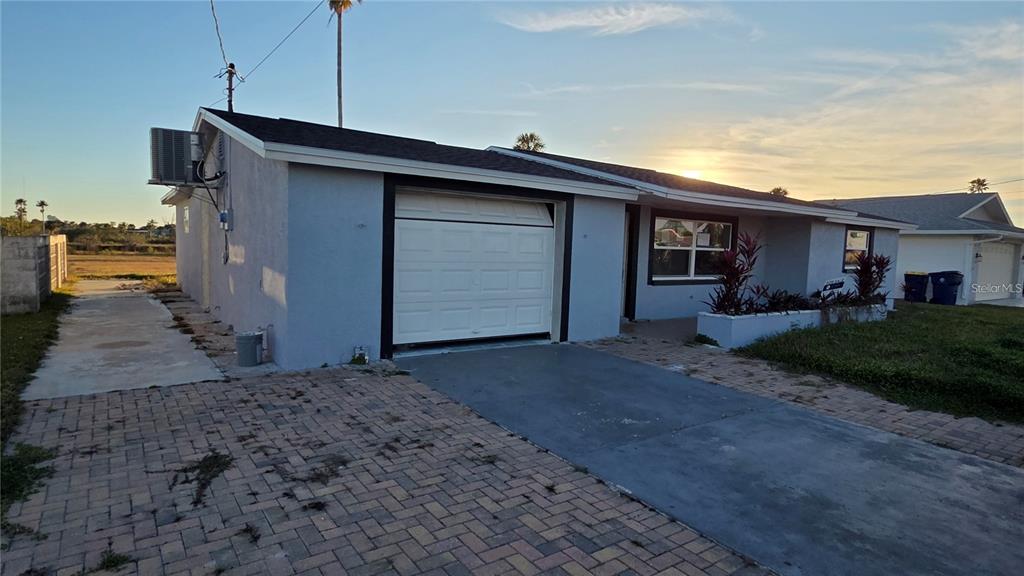 A single-story house with a light blue exterior, a garage, and a paved driveway — 4020 HEADSAIL DRIVE, NEW PORT RICHEY, FL