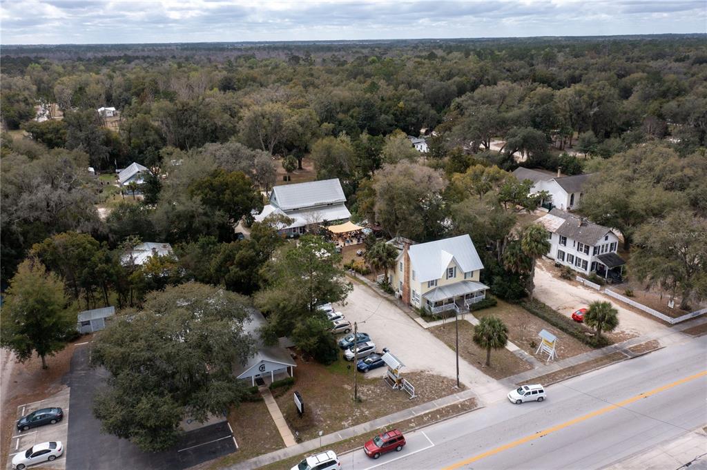 An aerial view shows several buildings, a parking lot, and trees along a paved road — 307/309 STATE ROAD 26, MELROSE, FL