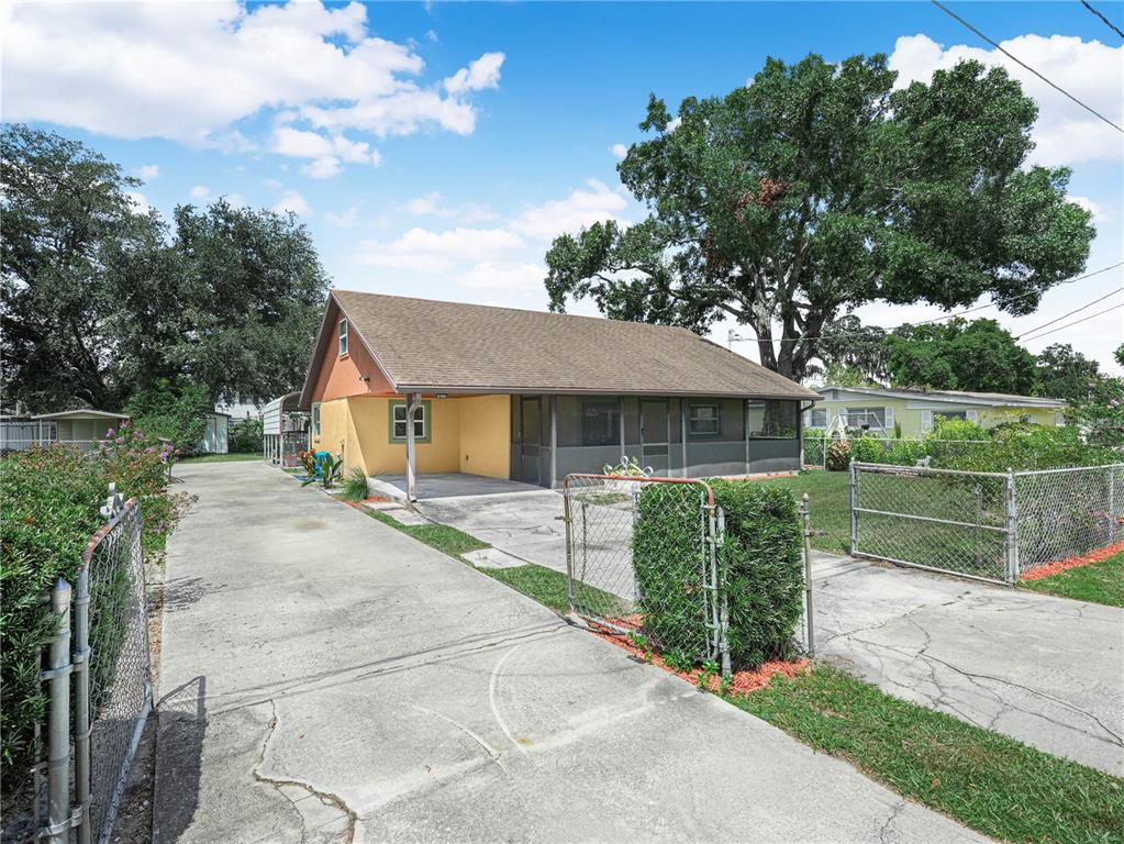 A single-story house with a brown roof, dark exterior walls, and a front porch — 1213 CHEROKEE DRIVE, KISSIMMEE, FL